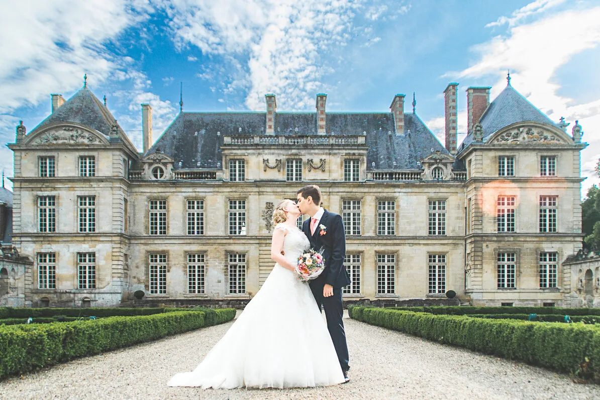 Les mariés s'échangent un baiser devant le Chateau de Raray