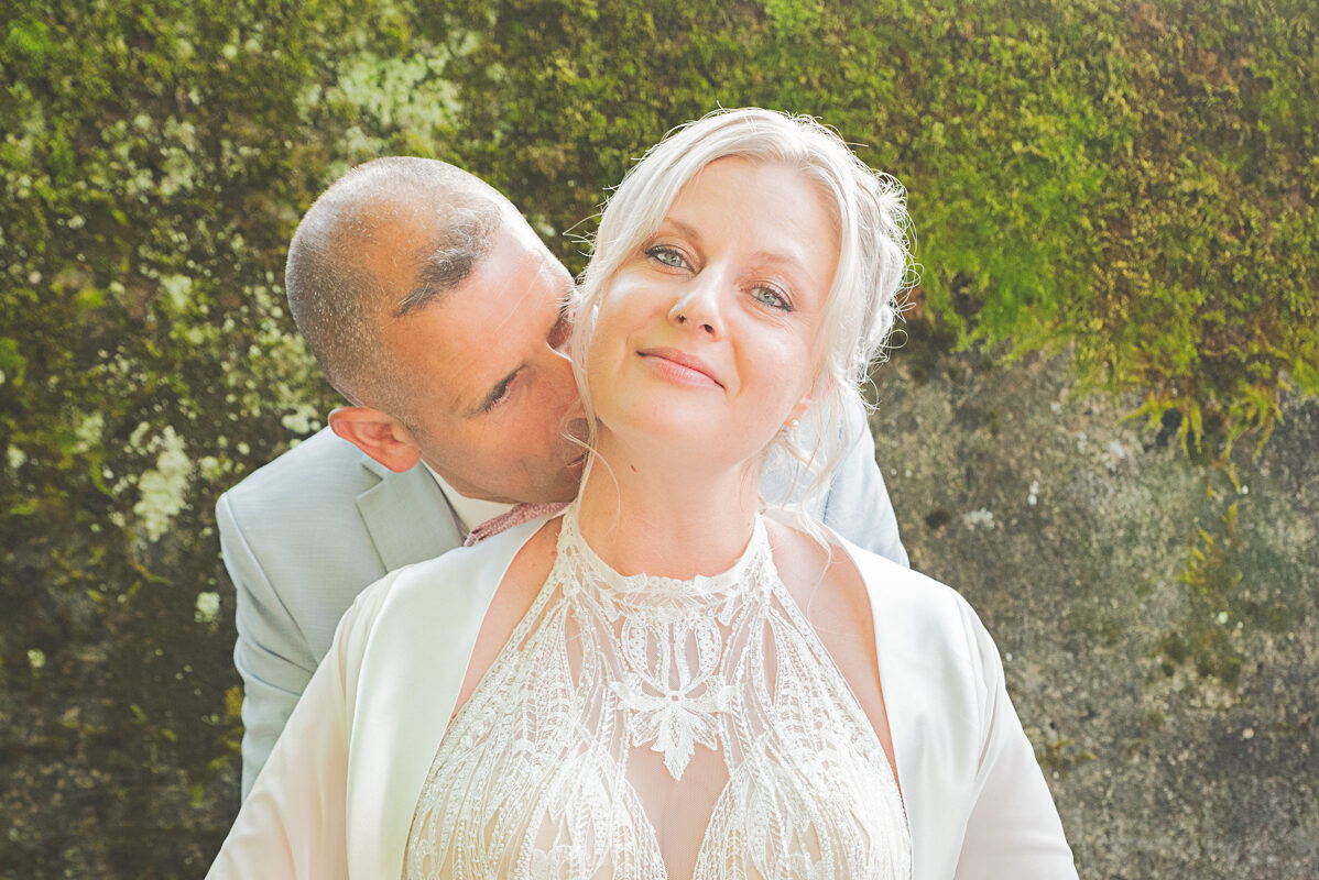 Douceurs maritales - Photographe de tendresse à Nancy Photo des mariés pendant la séance couple, le marié dépose un bisou dans le cou de sa femme.