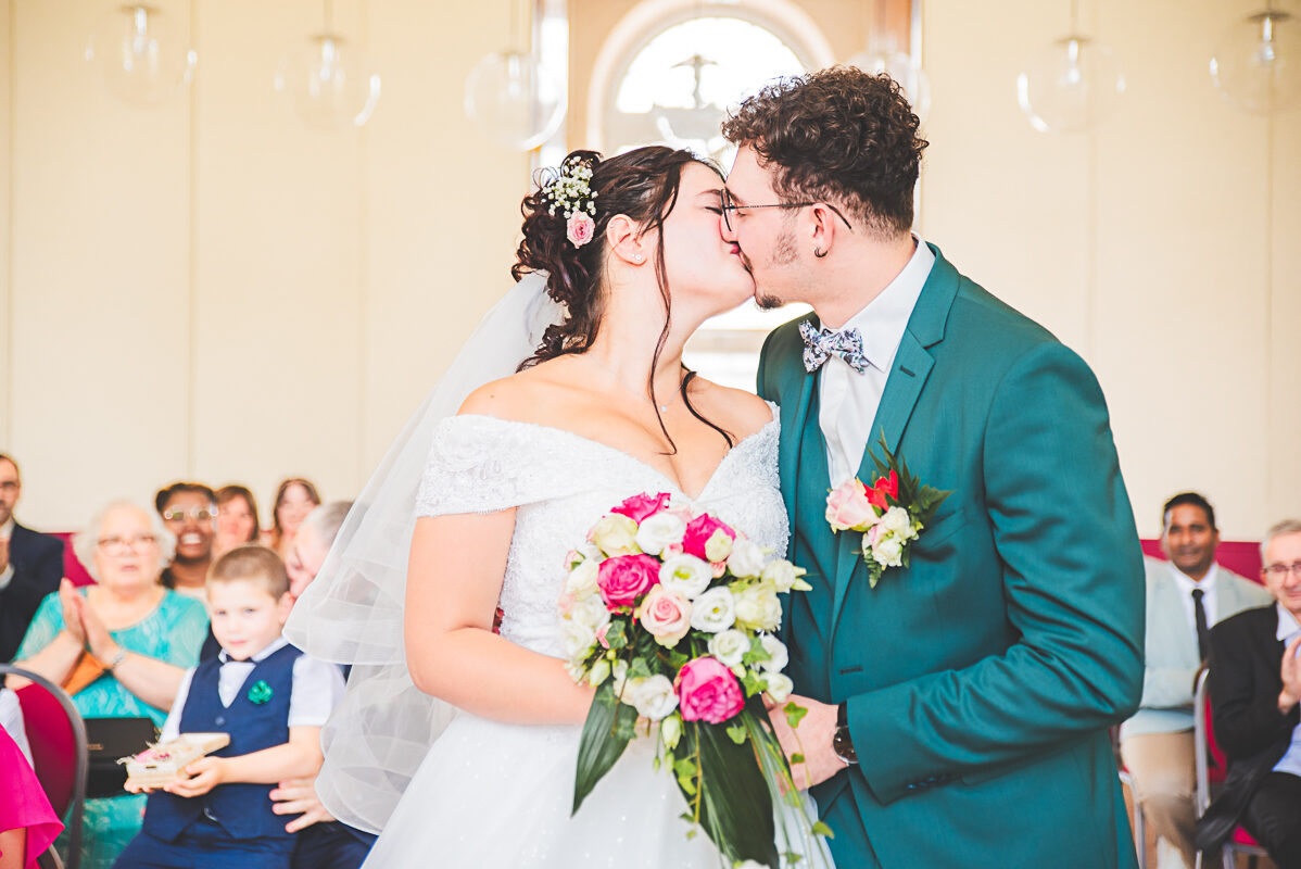 Baisé floral - Photographie des mariés bouquet à la main. Un baisé devant le maire, échangé par le jeune couple de mariés devant l'adjointe du maire de Toul