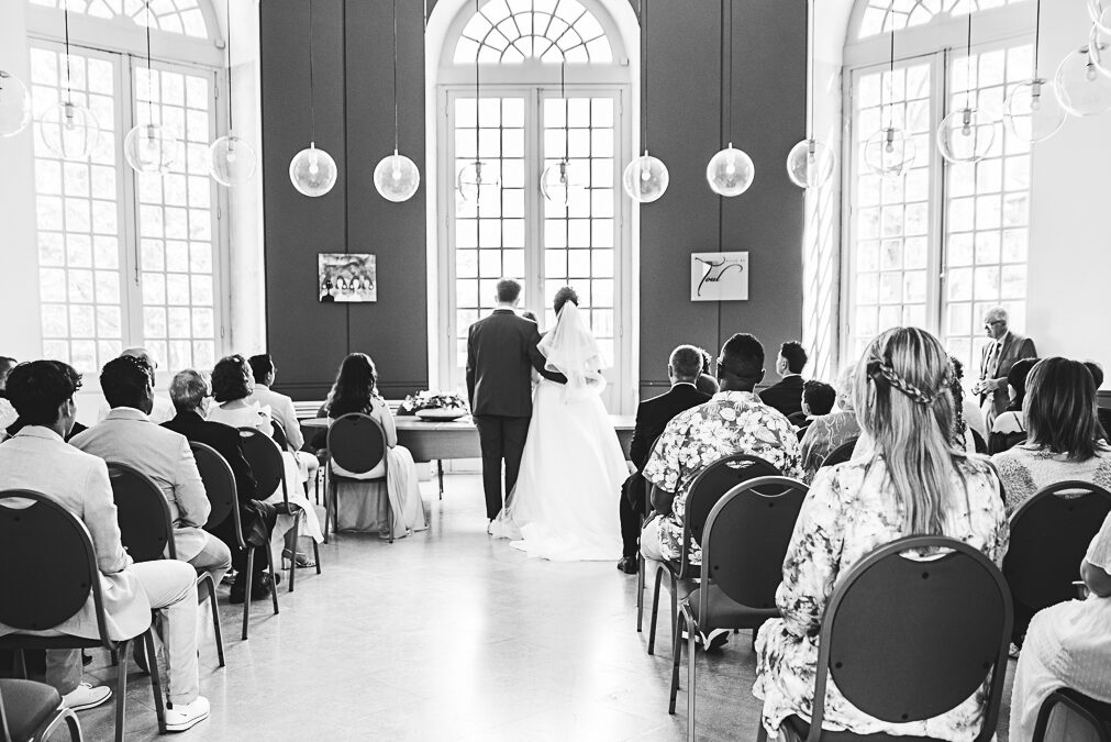 Les mariés de dos - Photo cinématographique des mariés à Toul L'assemblée d'invités et les mariés pris de dos dans la mairie de Toul