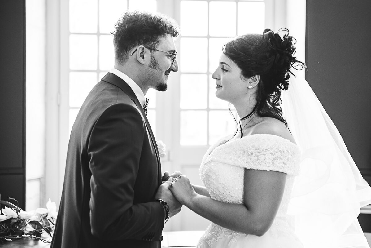 Le regard de l'amour - Photo à la belle mairie de Toul Les mariés se tiennent les mains, ils viennent de se dire oui et s'apprètent à s'embrasser dans la mairie de Toul