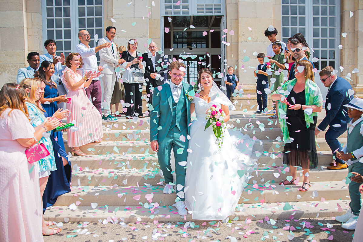 Une sortie sous les pétales de fleurs - Photo de mariage féérique à Toul Les mariés descendent les marches à la sortie de la mairie -Photographe de mariage à Toul - Mairie de Toul