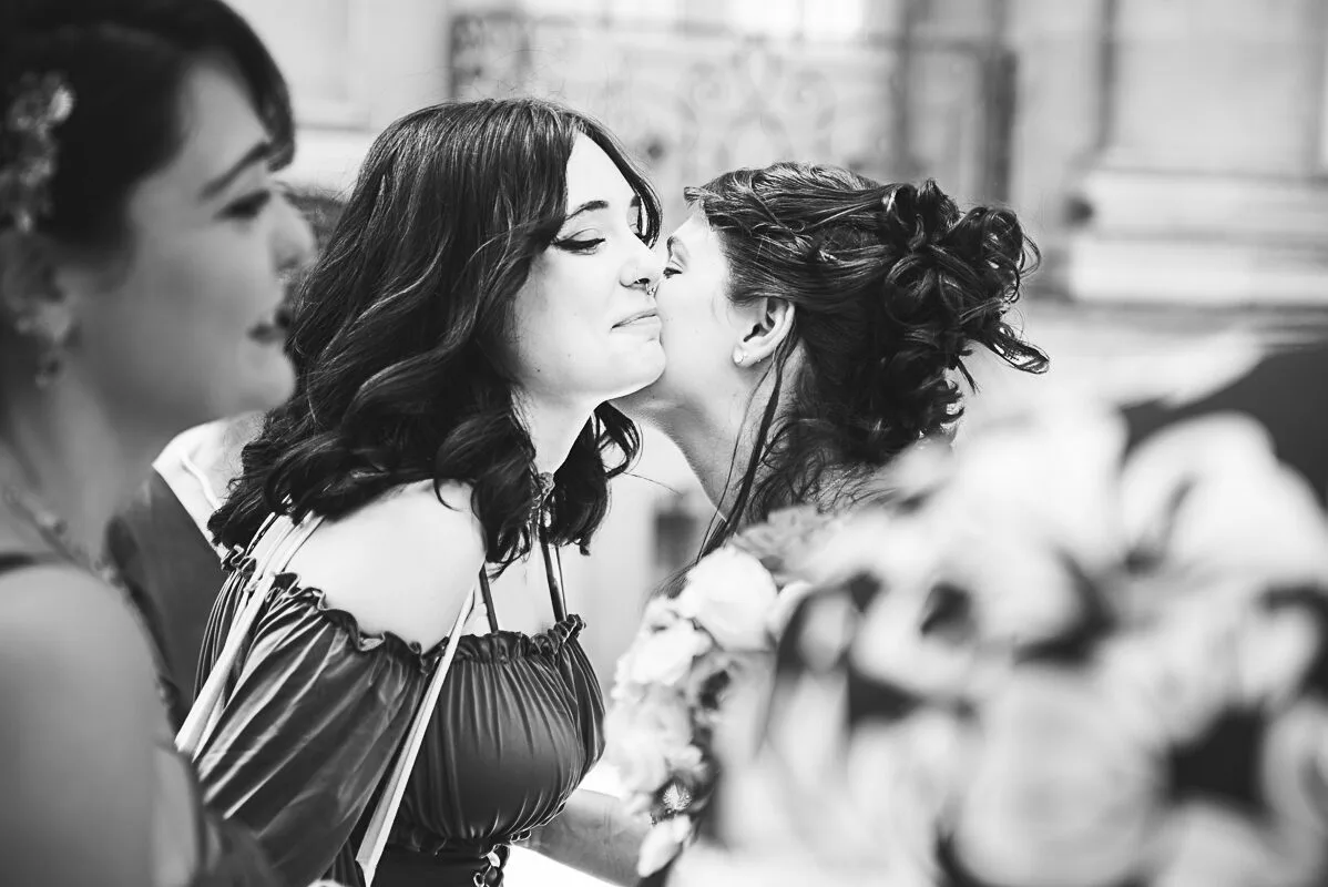 La mariée embrasse une invitée, des retouvailles émouvantes.